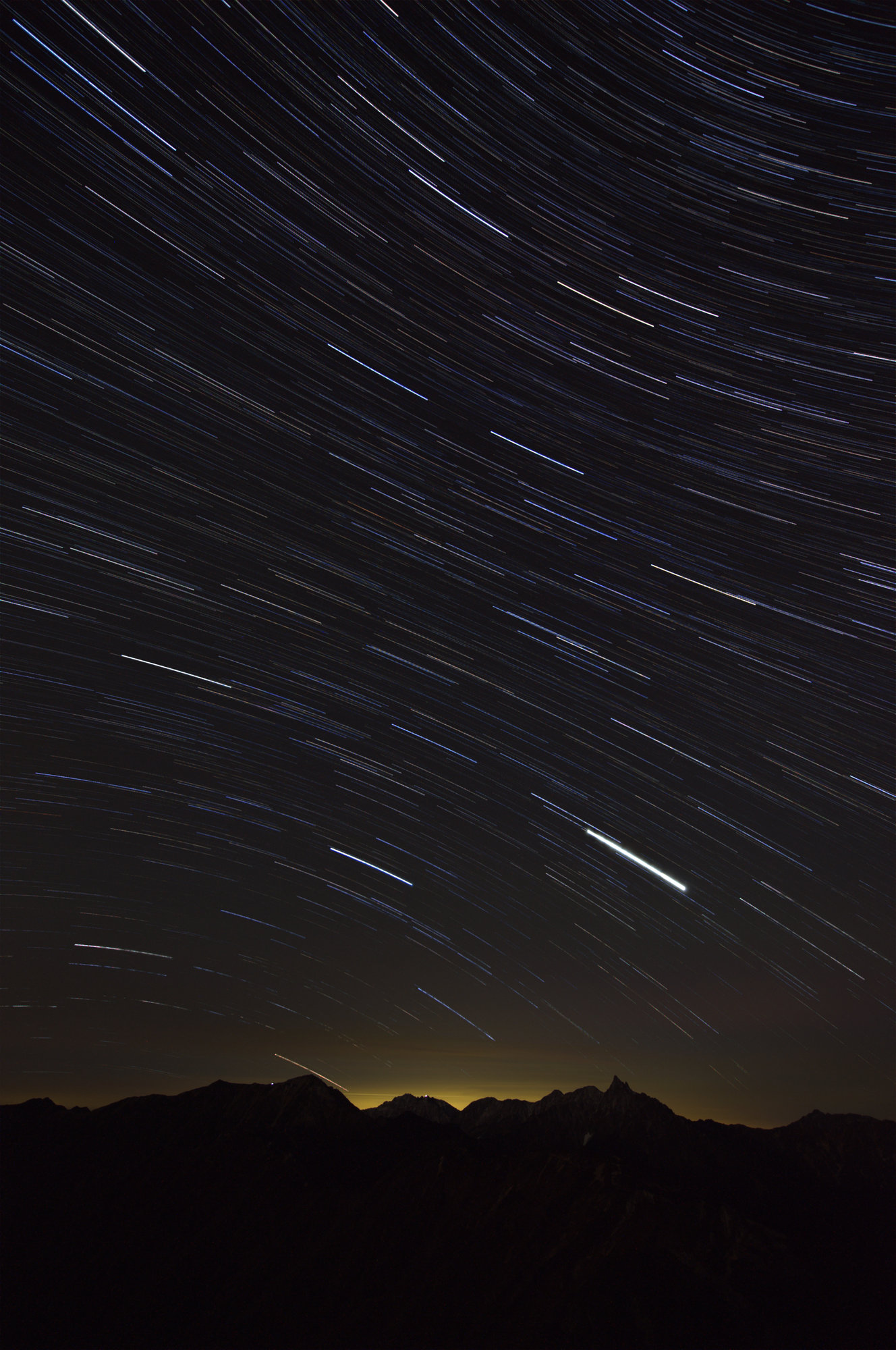 2009年10月11日の燕岳で連続撮影した星景のうち300枚を、NEFから既定の現像設定で取り出し、比較明(各画素の最大値)で重ねただけの画像。槍ヶ岳などの稜線の上に、無数の星の軌跡が弧を描いている。縮小表示。