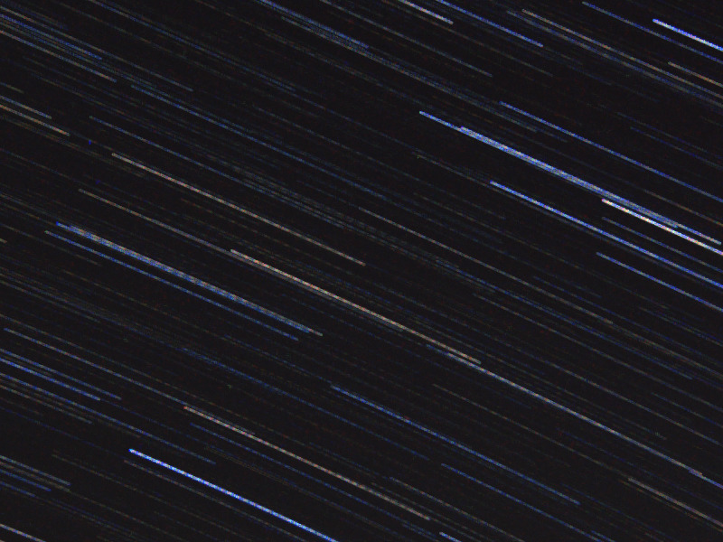 図1の一部を100%表示で切り出した画像。多数の星の軌跡が、なめらかな線ではなく、短い線が並んだように途切れて見える。切り出し以外の処理はしていない。